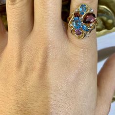 Metal: 14K Gold                                                                                                                                                                                                                                                                                                           Stone: Garnet, Blue Topaz , Amethyst And Diamond  Shape: Round, Pear-shape And Oval                                                                                                                                Approximate Gem Weight: 4.00 Carats 14k Gold Multi-stone Ruby Ring, 14k Gold Multi-stone Oval Ruby Ring, Oval Multi-stone Ruby Ring In 14k Gold, Oval Multi-stone Ruby Ring In Yellow Gold, Oval Multi-stone Ruby Ring For Anniversary, Colored Diamond Rings, Gold Stone, Matching Band, Multi Stone Ring