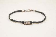 Men's bracelet with a silver tube charm and a gray cord, bracelet for men, gift for him, gift for bo Everyday Silver Bracelet With Waxed Cord, Silver Minimalist Bracelets With Waxed Cord, Masculine Silver Leather Bracelet As A Gift, Mens Gray Bracelet, Masculine Black Band Adjustable Bracelet, Masculine Silver Leather Bracelet, Masculine Braided Leather Bracelet For Gift, Guy Gifts, Festival Jewelry