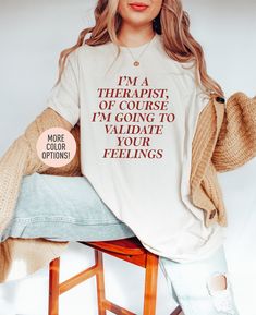 "This I'm A Therapist Of Course I'm Going To Validate Your Feelings Shirt is the perfect birthday gift or Christmas gift for all women! All of our shirts are made with the highest quality materials and are super soft and cozy! 💚 HOW TO ORDER 💚 1. Check our photos for sizing and color options. 📏 2. Choose your quantity.  Feel free to add as many shirts as you wish! ✨ 3. Select your size and color from the drop-down menus. ✨ 4. Click \"ADD TO CART\" to add the shirt to your virtual cart. 🛒 5. Relaxed Fit Shirt With Funny Text For Gift, White Slogan Shirt As A Gift, White Slogan Shirt For Gift, Counselor Outfits Women, Therapist Outfits Women, Therapy Outfits, Salon Merch, Validate Your Feelings, Therapist Outfit