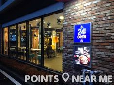 the front of a restaurant at night with neon lights on it's glass windows