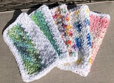 four crocheted dishcloths sitting on top of a table