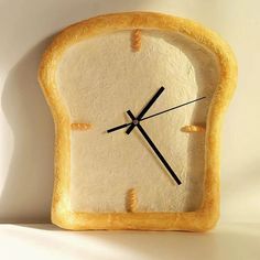 a close up of a clock made to look like a slice of bread with black hands