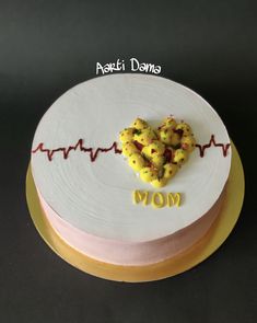 a heart shaped cake sitting on top of a plate with the word mom spelled in front of it