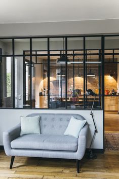 a couch sitting in front of a glass wall