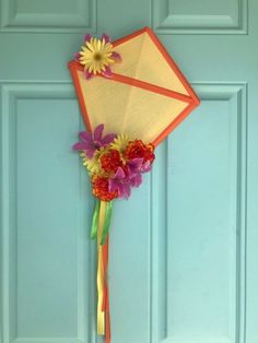 a kite with flowers attached to it hanging on a door