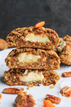 three cookies stacked on top of each other with cheese and pecans scattered around them