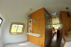 an inside view of a small house with lots of wood and white carpeted flooring