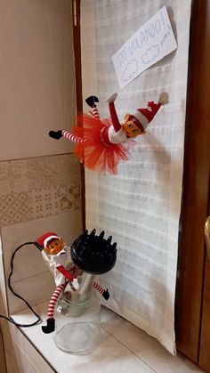 two elfs are standing on top of a counter with an object in front of them