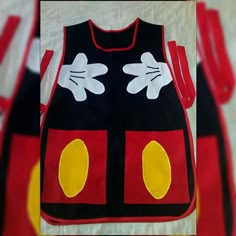 the mickey mouse shirt is on display in front of a white backdrop with red, yellow and black designs