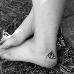 a person's foot with a small triangle tattoo on the side of their leg