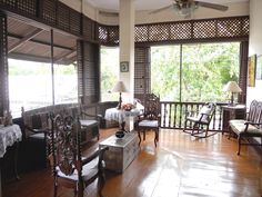 a living room filled with furniture and windows covered in blinds on top of wooden floors