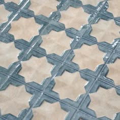 a close up view of a tile floor with blue and beige tiles on the ground