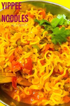 a bowl filled with noodles and vegetables on top of a yellow table