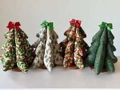 four small christmas trees sitting on top of a table