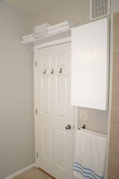 a bathroom with white doors and towels hanging on the rack above it's door