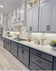 a kitchen filled with lots of white and gray cabinets