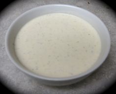 a white bowl filled with liquid sitting on top of a table