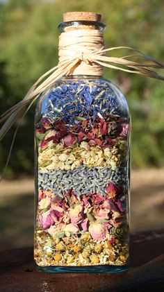 a bottle filled with flowers and herbs sitting on top of a table