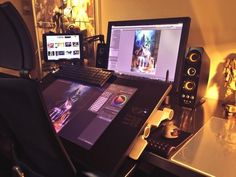 a laptop computer sitting on top of a desk next to a monitor and speaker system