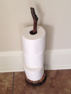 a roll of toilet paper sitting on top of a wooden stand next to a wall