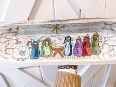 the nativity scene is painted on an old wooden plank