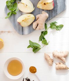 the ingredients for this tea include apples, ginger, mint and ginger seeds on a cutting board