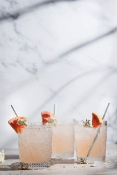 two glasses filled with drinks sitting on top of a table