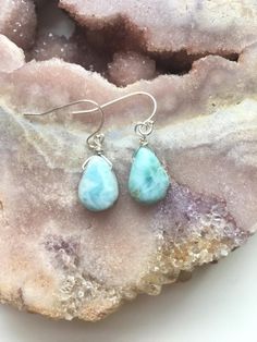 A beautiful dainty polished and drilled  pair of Larimar in a simple tear drop shape will be placed on a dainty sterling silver or 14k gold filled ear hooks. These Larimar earrings  have the most beautiful soothing blue shades. With its light blue and white swirls this will make the perfect piece of Larimar jewelry in your collection. Each pendant differs from the next they are about 1/2" 💙 sea and sky energies 💙 serenity 💙 relaxation 💙 worry stone 💙 emotional cleanser and healer 💙 helps r Blue Larimar Earrings For Gift, Blue Larimar Dangle Earrings, Larimar Dangle Earrings For Gifts, Raw Rose Quartz Necklace, Larimar Earrings, Raw Stone Necklace, Blue Drop Earrings, Raw Crystal Jewelry, Raw Rose Quartz