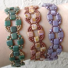 three different bracelets on someone's arm, one with beads and the other with stones