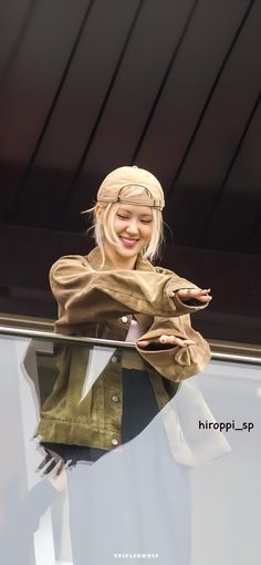 a woman is standing on top of a window sill wearing a headscarf