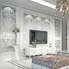 an elegant living room with white walls and chandelier hanging from the ceiling, along with a footstool