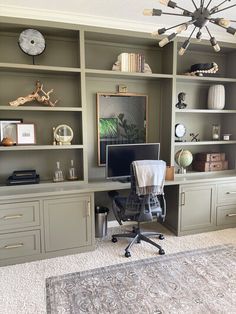 a home office with built - in bookcases, desk and computer on the far wall