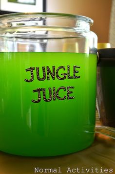 a green jug with the words jungle juice in black lettering on it sitting on a table