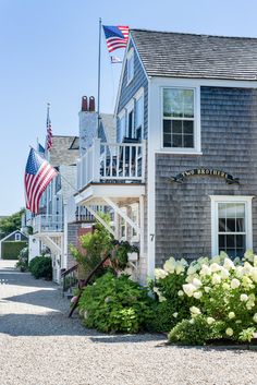 an american flag is flying in front of a row of houses with flags on the roof