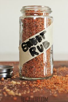 a jar filled with spices sitting on top of a wooden table