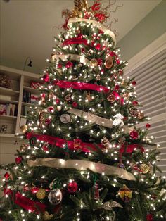 a decorated christmas tree with red, white and gold ornaments