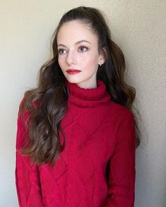 a woman with long hair wearing a red sweater