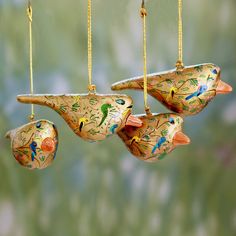 three ceramic birds hanging from chains on a string