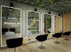 the interior of a hair salon with chairs and plants growing on the wall behind them