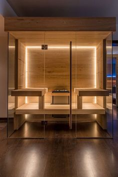 an empty room with wooden shelves and lights on the walls, along with wood flooring