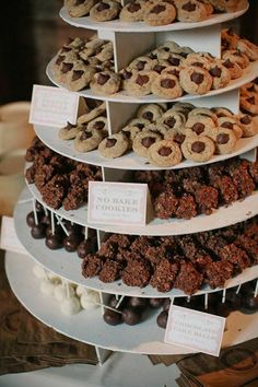 three tiered trays filled with different types of cookies and pastries on top of each other