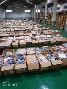 many boxes are stacked on the floor in an empty warehouse