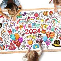 two children are drawing on a large new year's card