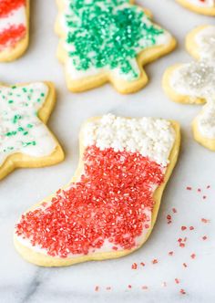 christmas cookies decorated with red, white and green sprinkles on a marble surface