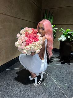 a woman with pink hair holding a bouquet of roses