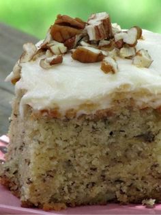 a piece of cake with white frosting and nuts on top