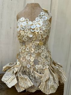 a dress made out of old book pages and buttons