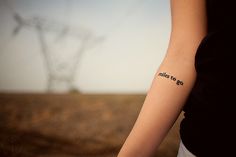 a woman with a tattoo on her arm that says, always to go in front of a power line