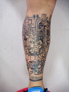 a man's leg with a tattoo on it and an electronic circuit board in the background