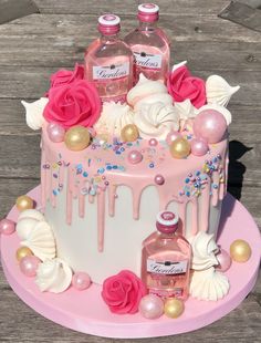 a cake decorated with pink and white icing, roses, confetti, and bottles of booze